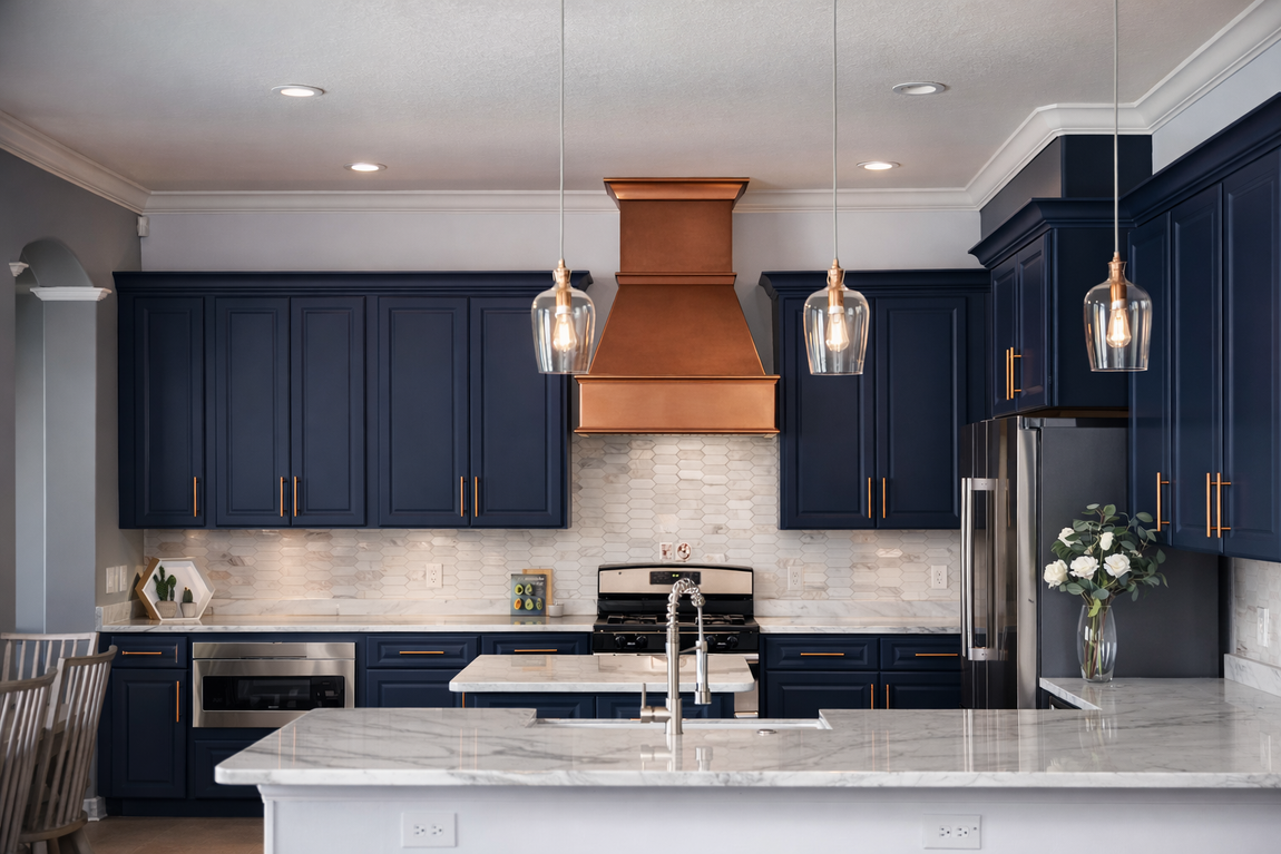 Blue kitchen cabinets with copper range hood and pendant lights.