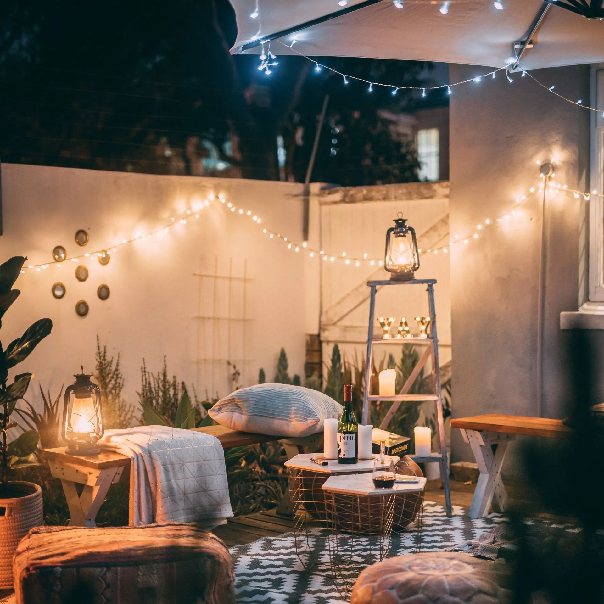 A patio with a lot of furniture and lights at night