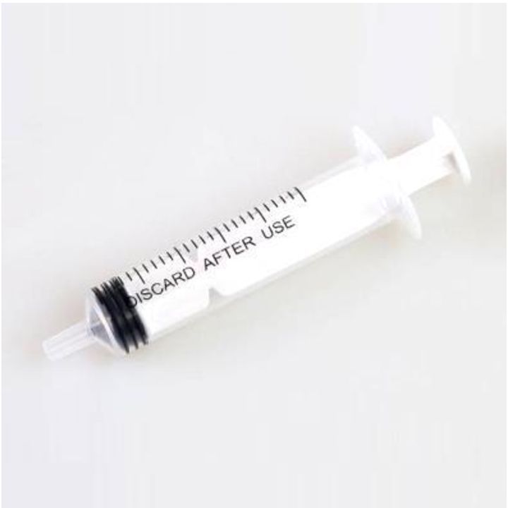 Jeringa de plástico blanca con émbolo negro y la inscripción 