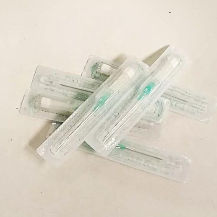 Agujas de acupuntura estériles y selladas en envases de plástico transparente, apiladas sobre una superficie blanca.