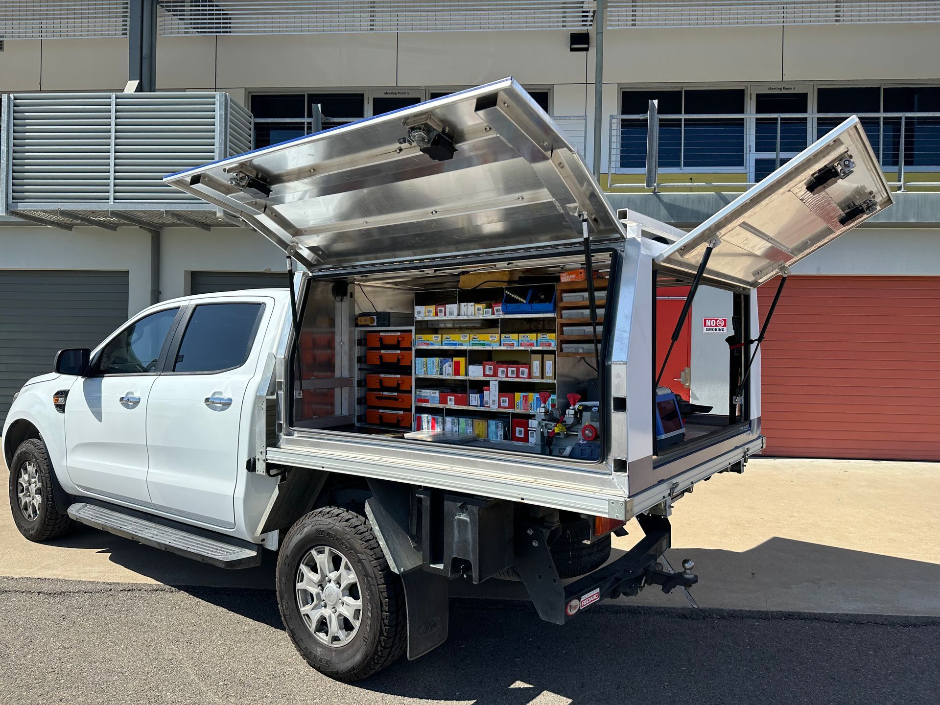 A Man In A Black Shirt Is Working On A Door Lock — Lock It Up Townsville In Aitkenvale, QLD