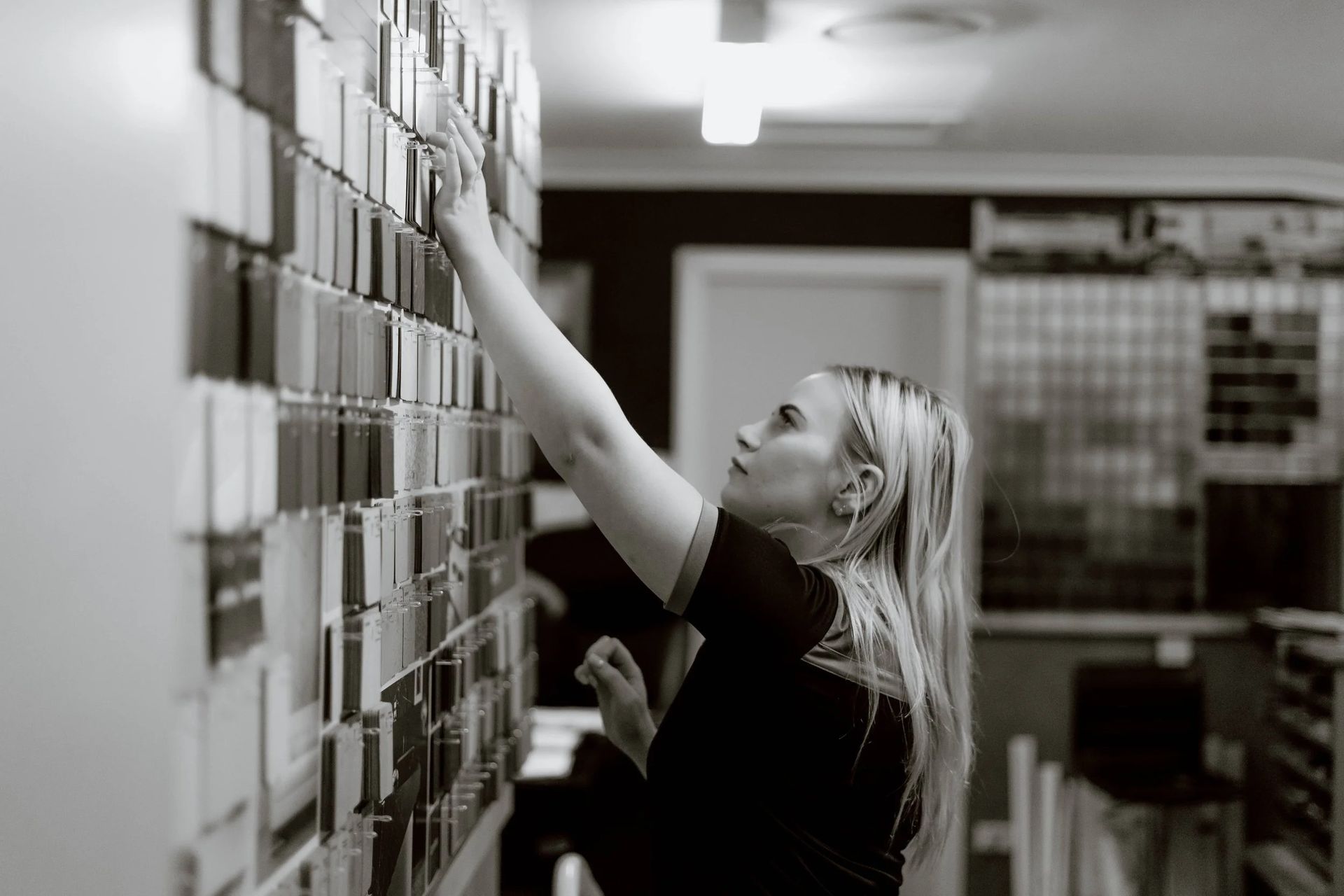 Woman Reaching for a Card on a Wall Covered With Cards — Onyx Detailed Joinery in Unanderra, NSW