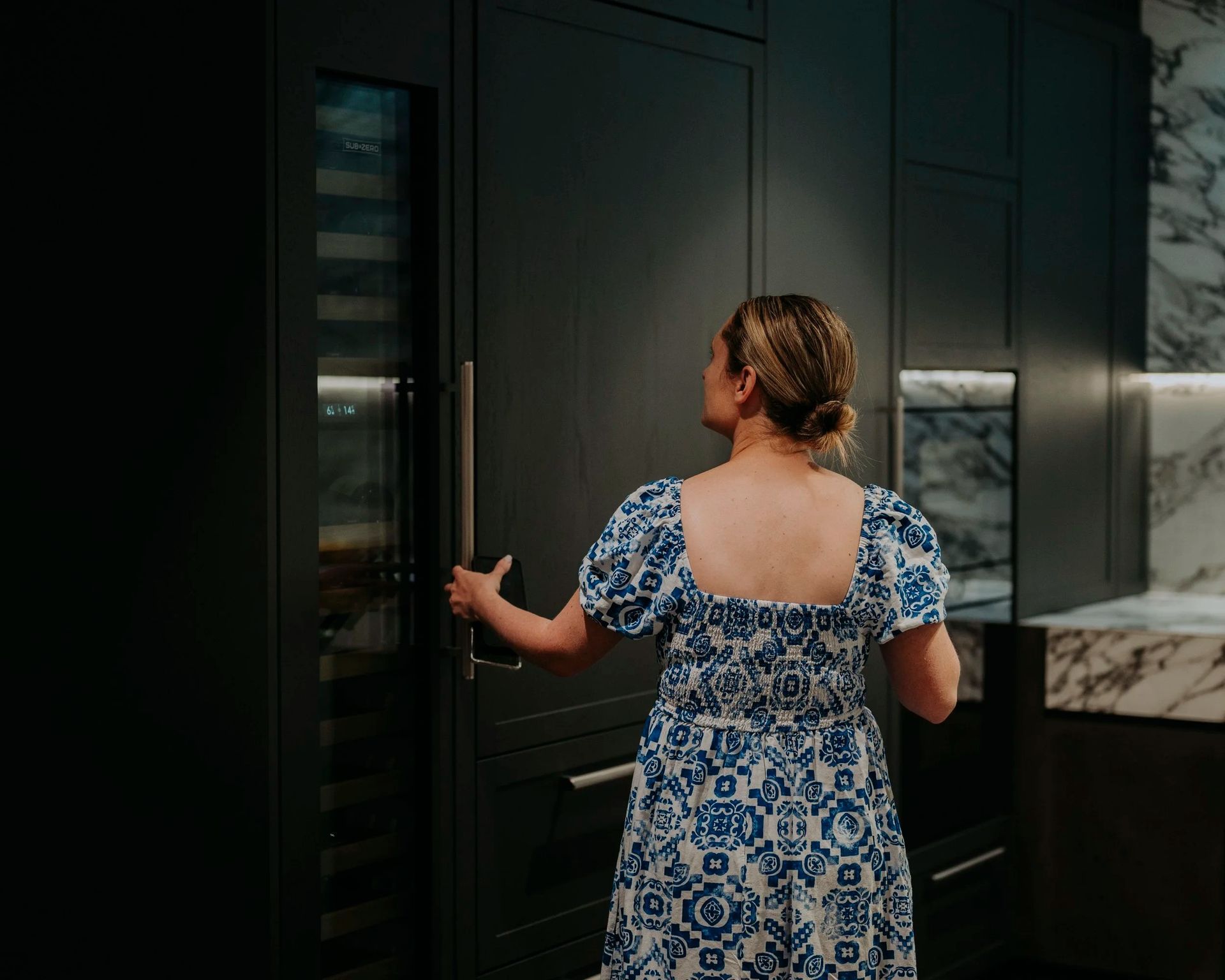 Woman in Blue Dress Opens a Dark Kitchen — Onyx Detailed Joinery in Unanderra, NSW