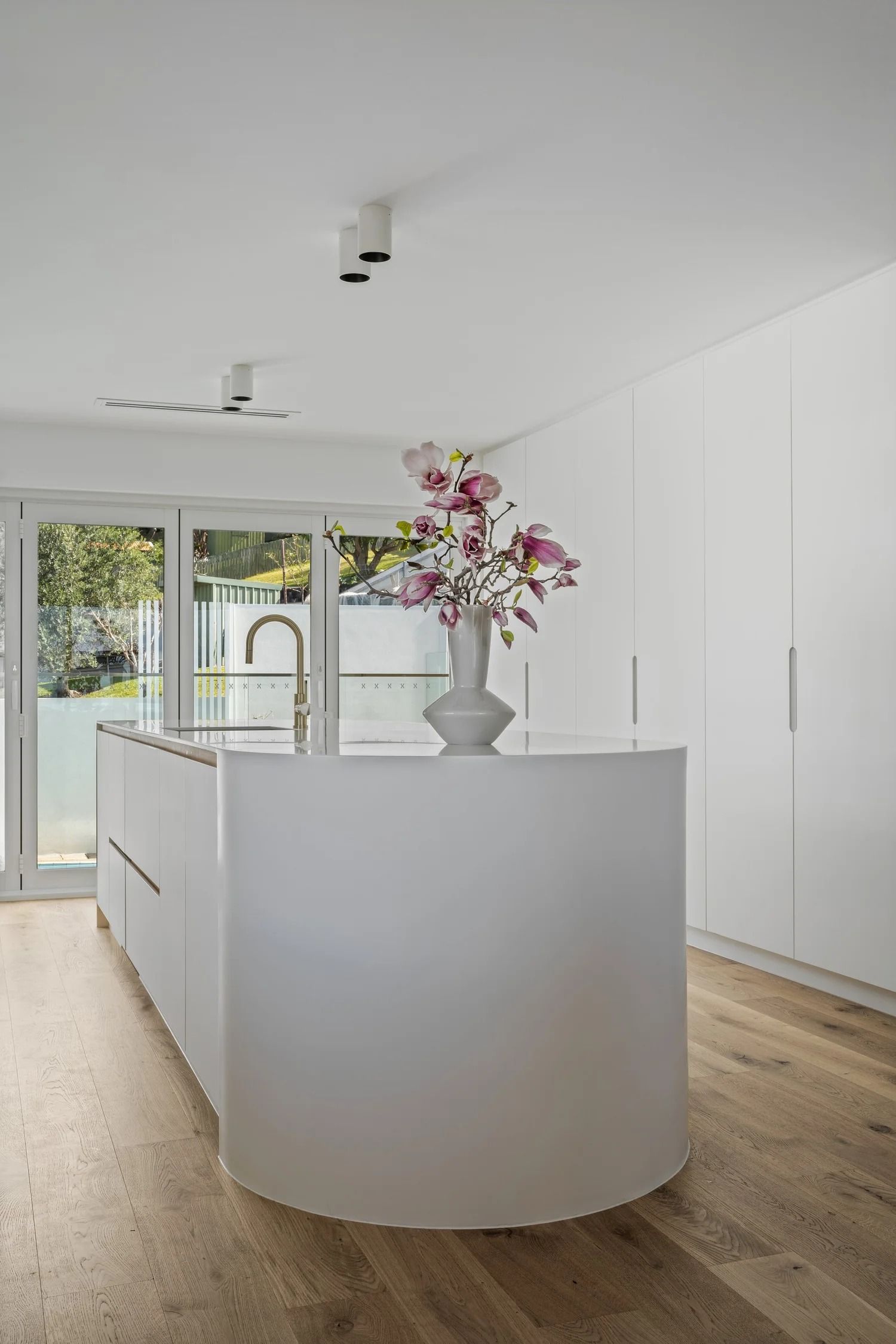 White Kitchen With Curved Island — Onyx Detailed Joinery in Unanderra, NSW