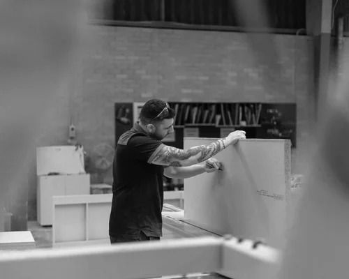 Man Working in a Workshop; Assembling a White Panel on a Table — Onyx Detailed Joinery in Unanderra, NSW