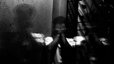 A man is sitting on the floor using a laptop computer.