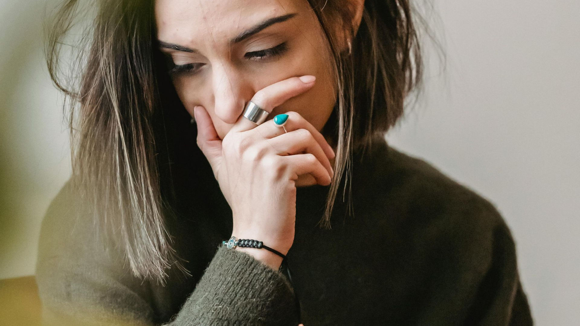 A man is hugging a woman who is crying in front of a mirror.