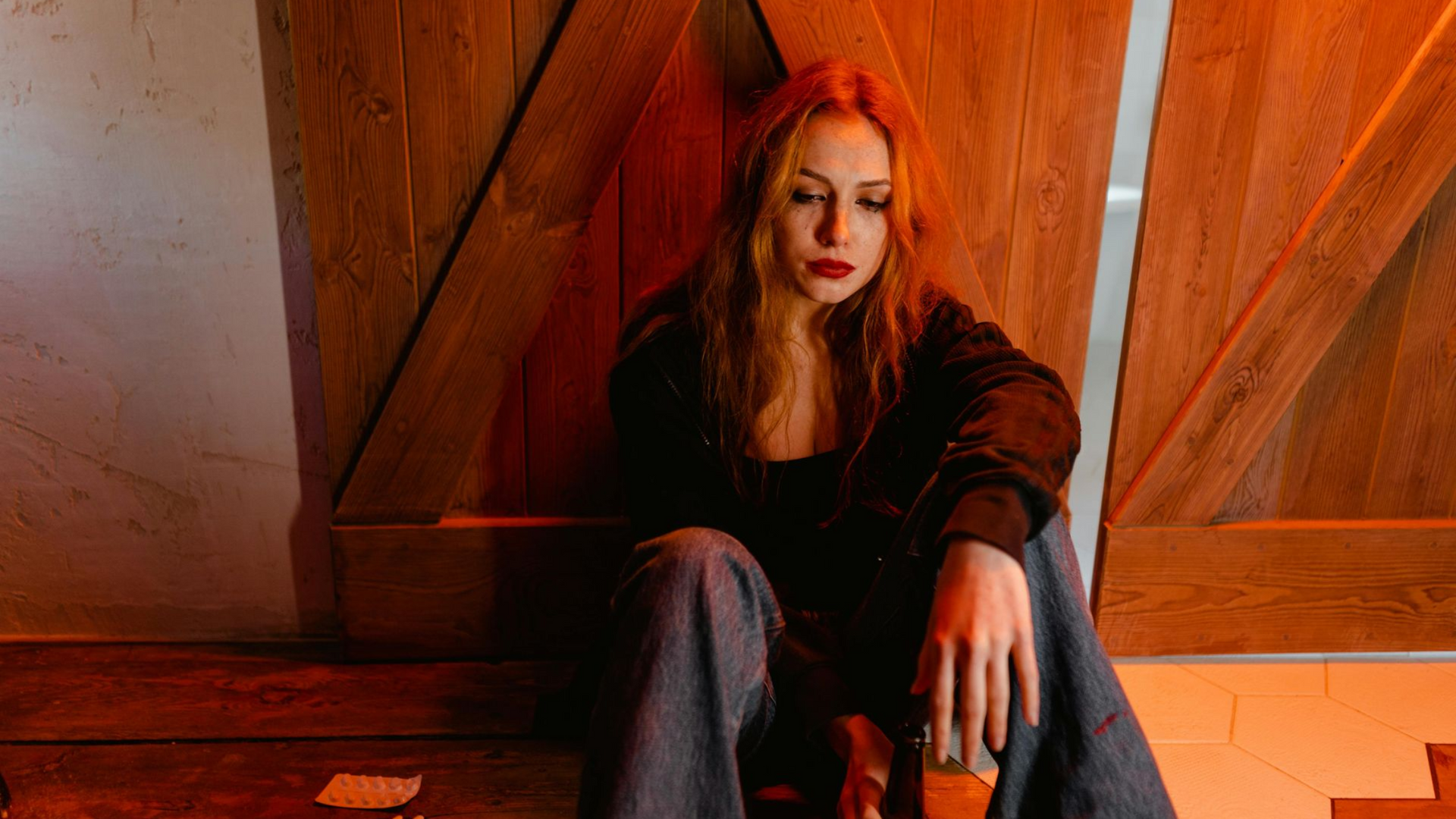 A man is hugging a woman who is crying in front of a mirror.