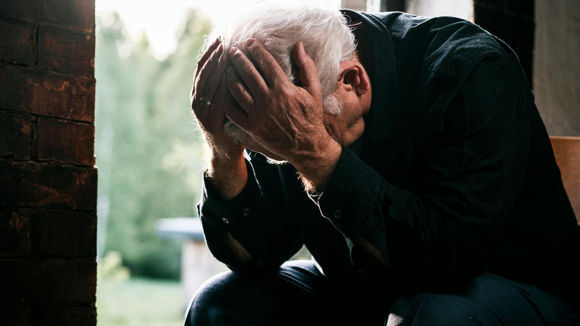 A man is sitting on the floor using a laptop computer.