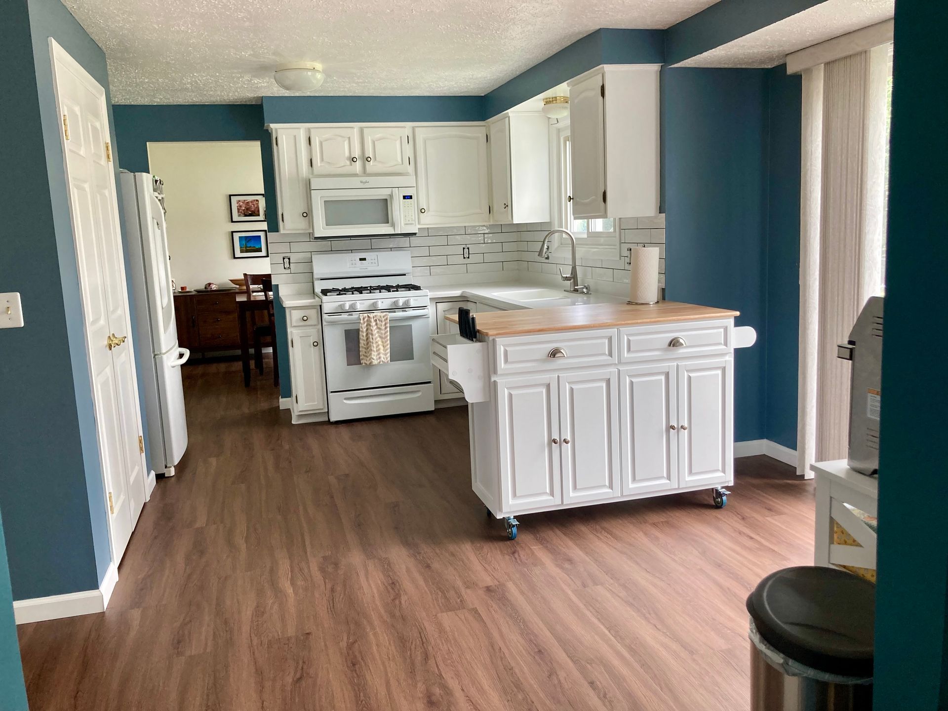 A kitchen with white cabinets and blue walls