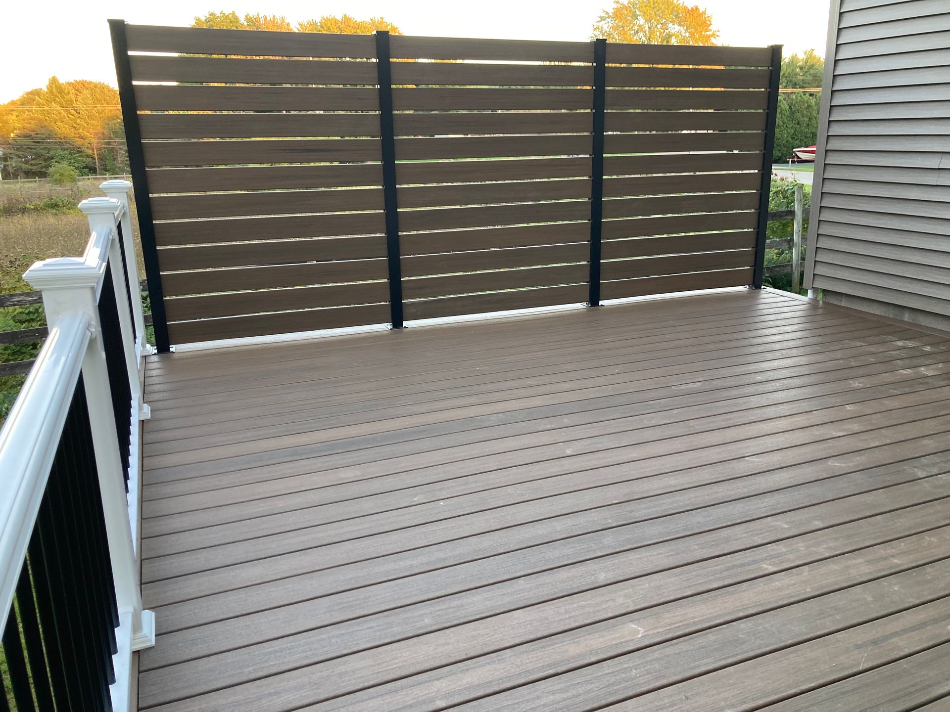 A wooden deck with a fence and a white railing