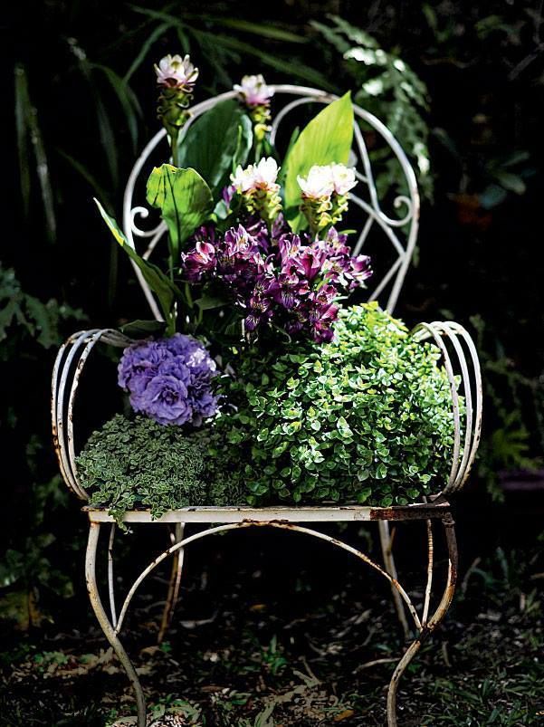 allestimento floreale viola e lilla su una sedia bianca elegante