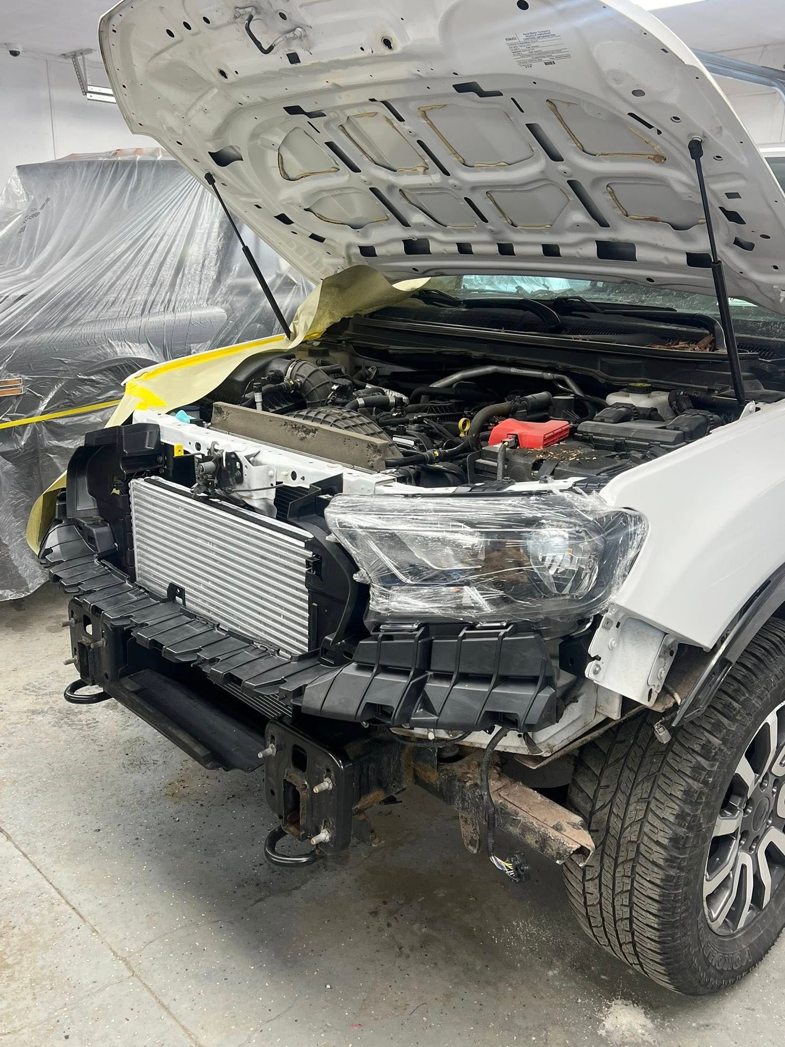 White Range Rover Evoque SUV parked outdoors on a paved area, front view.