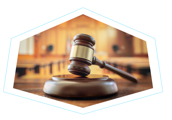 A judge 's gavel is sitting on a wooden table in a courtroom.