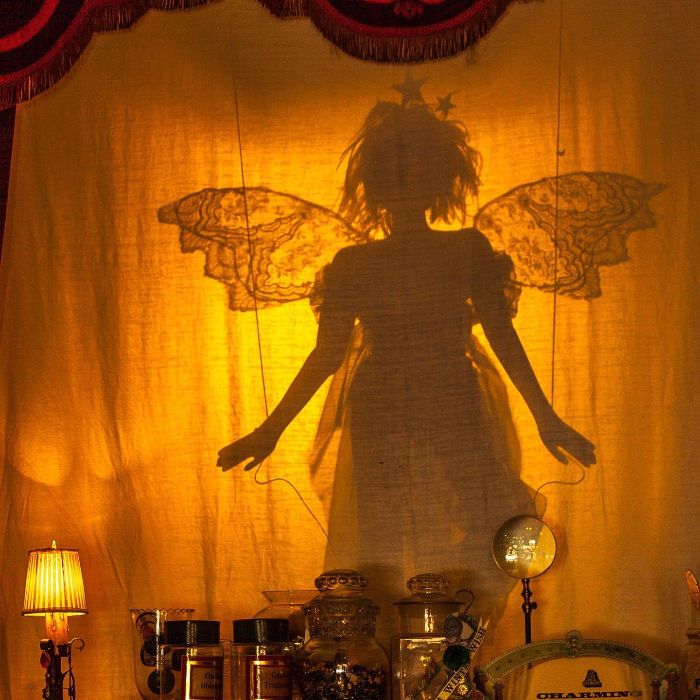 A shadow of a woman with wings is cast on a wall