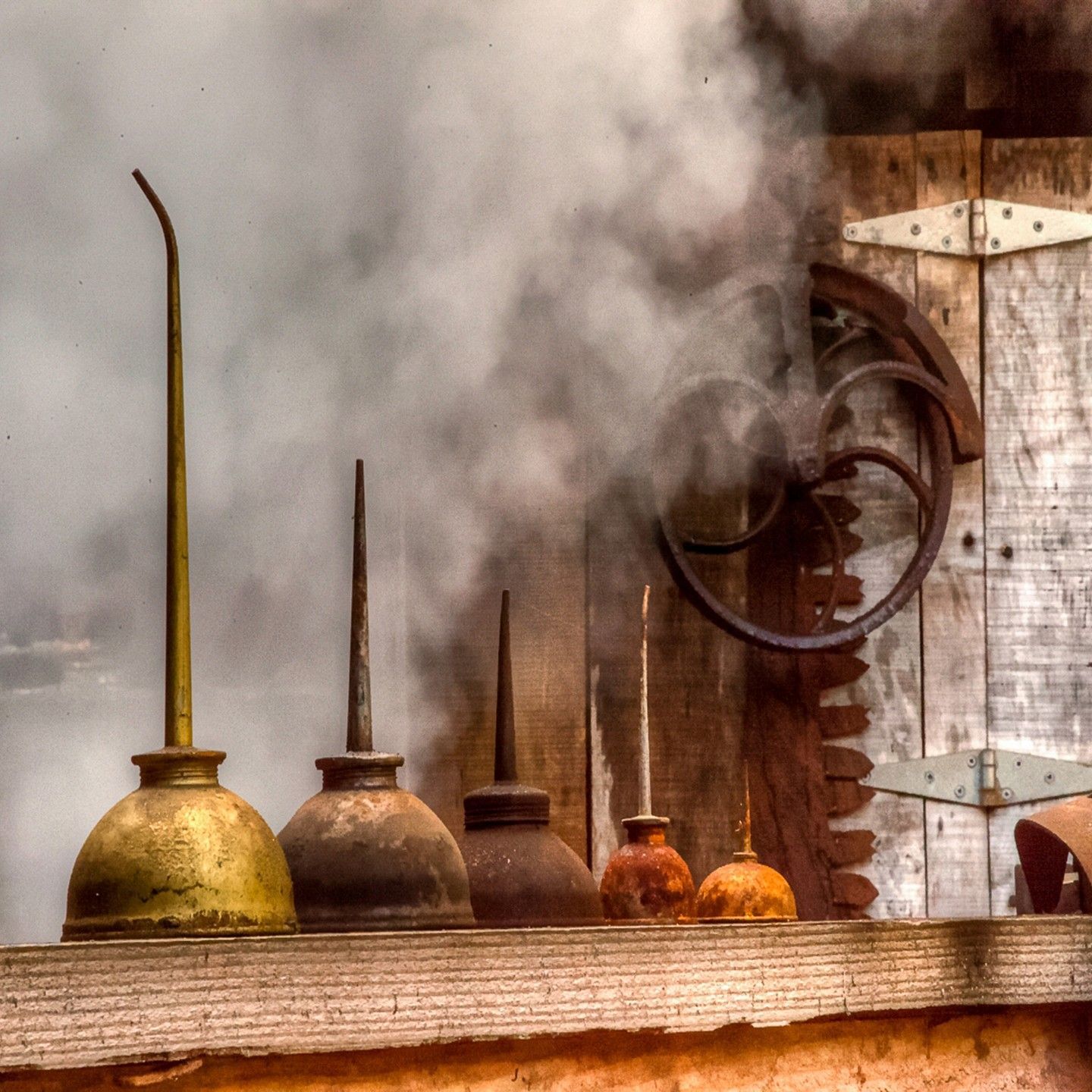 A row of oil cans with smoke coming out of them