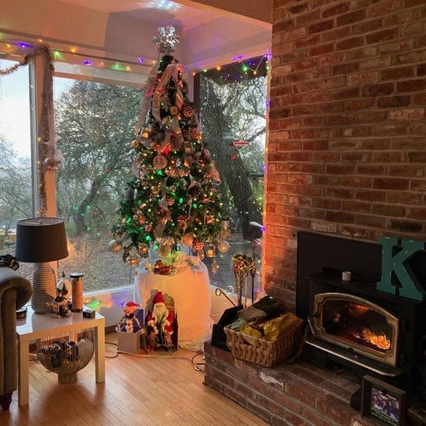 A living room with a fireplace and a christmas tree