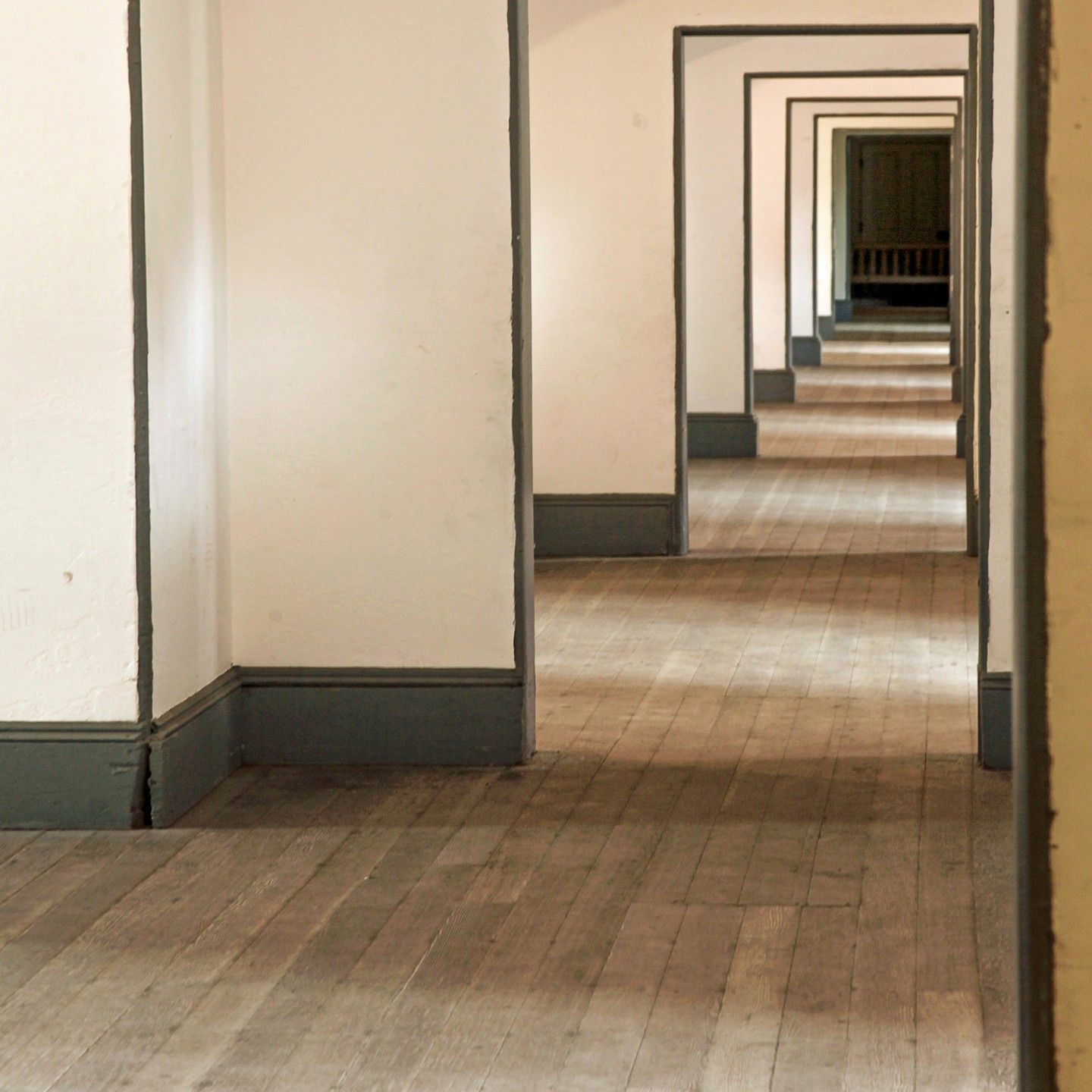 A long hallway with wooden floors and white walls