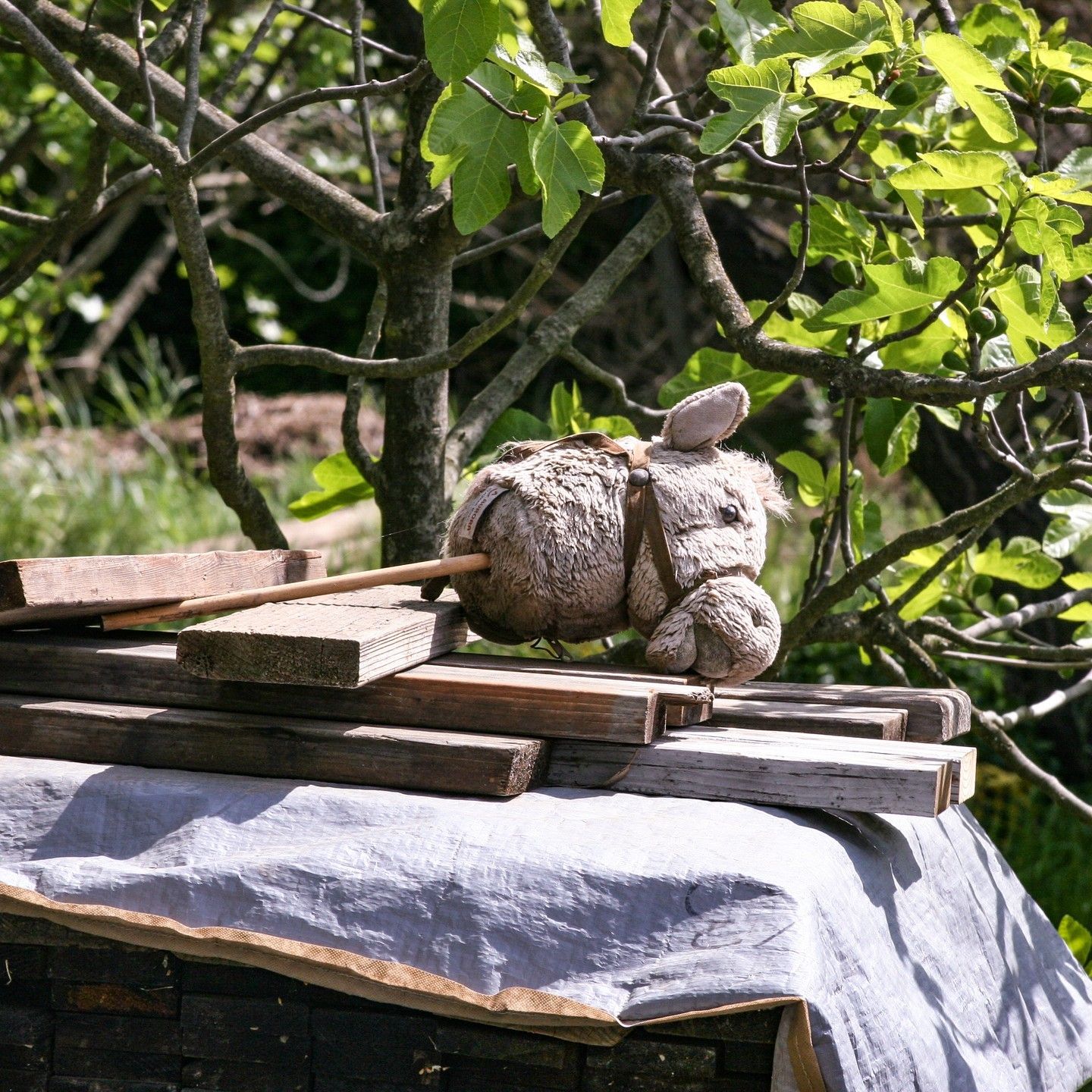 A stuffed animal is sitting on a pile of wood
