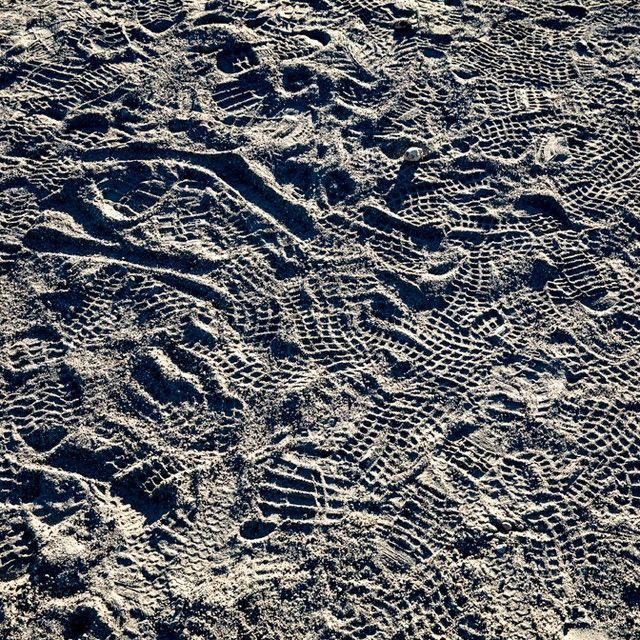 A black and white photo of footprints in the sand