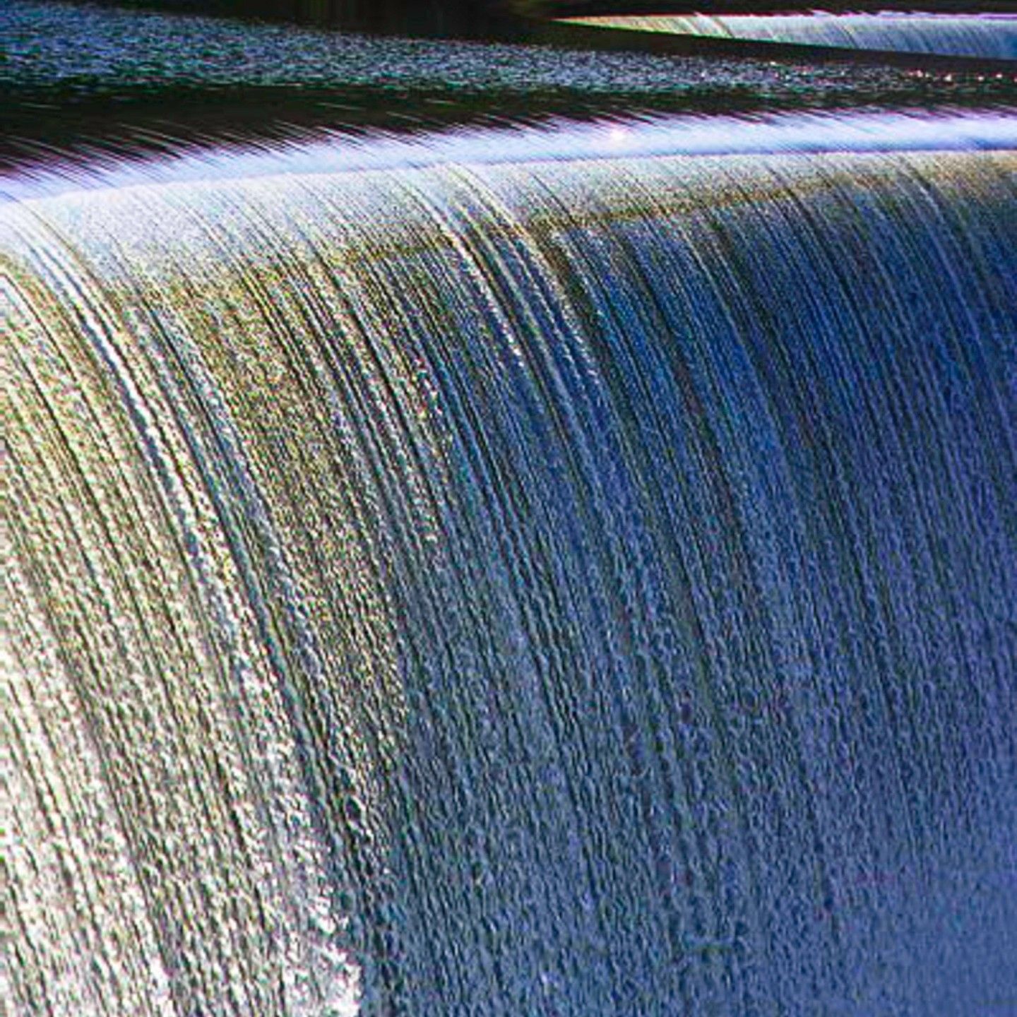 A close up of a waterfall with a lot of water coming down it.
