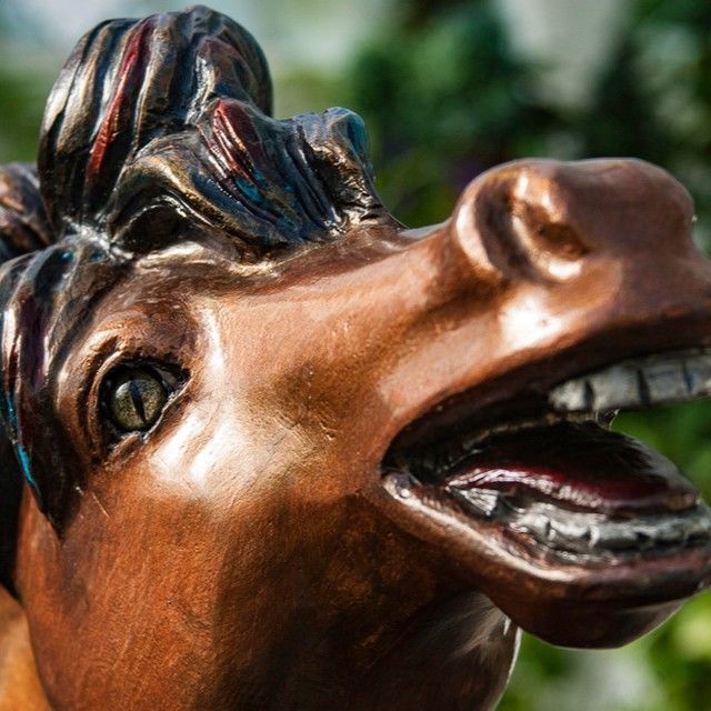 A statue of a horse with its mouth open