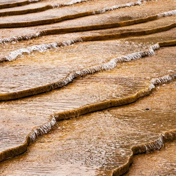 A close up of a swirling stream of water on a rocky surface.