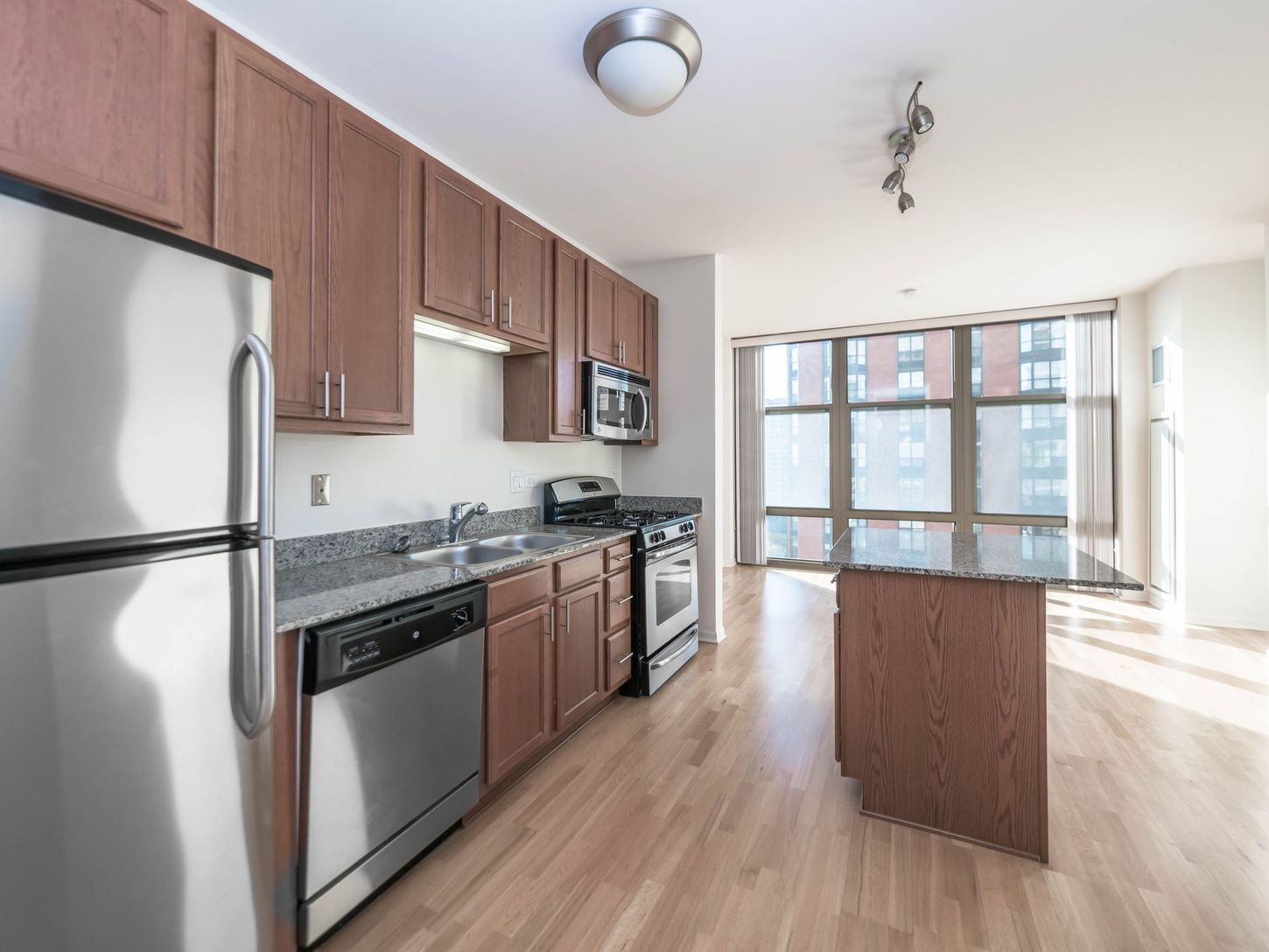 A kitchen with stainless steel appliances and wooden cabinets