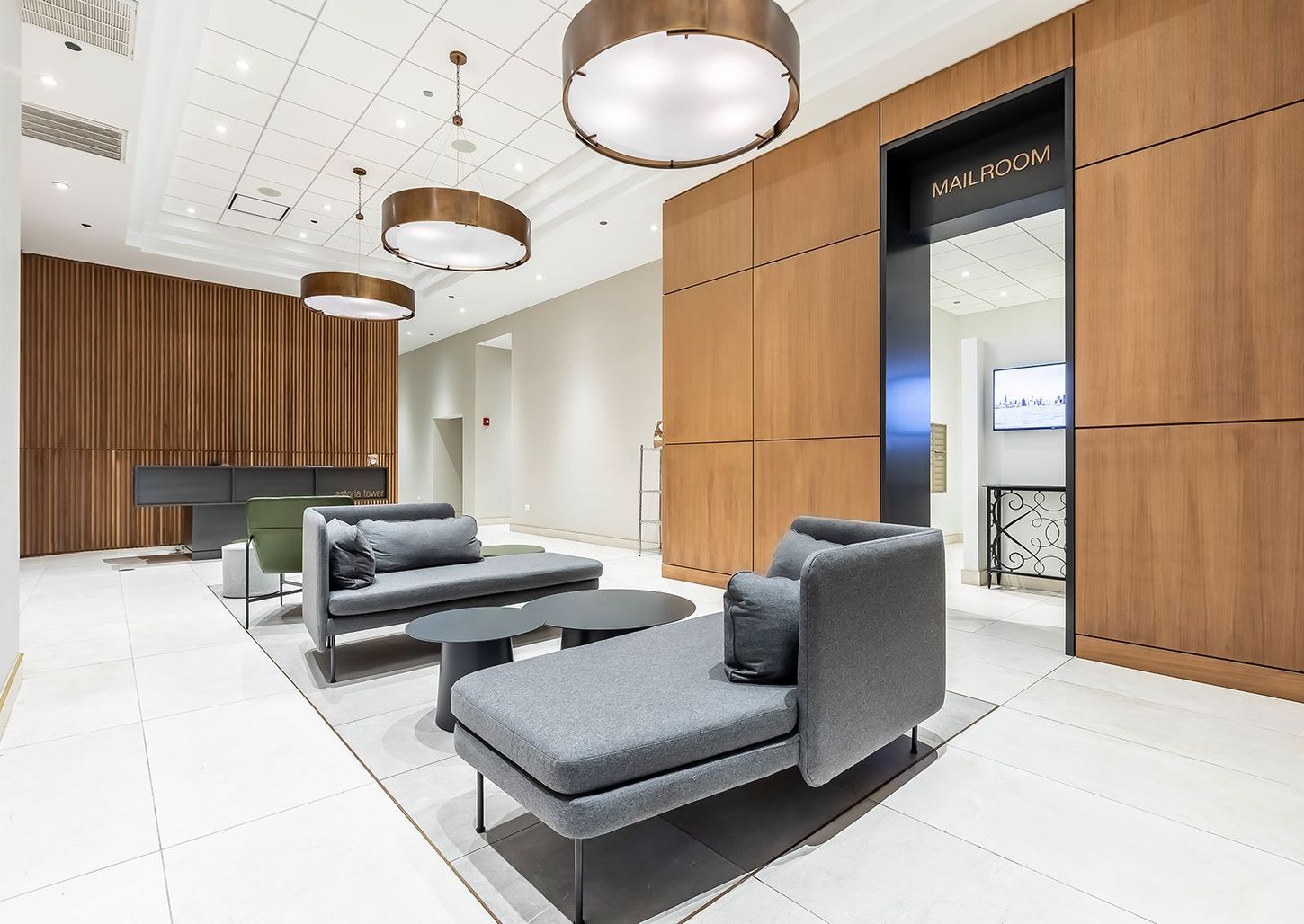 A lobby with a couch , chair , table and lamps.