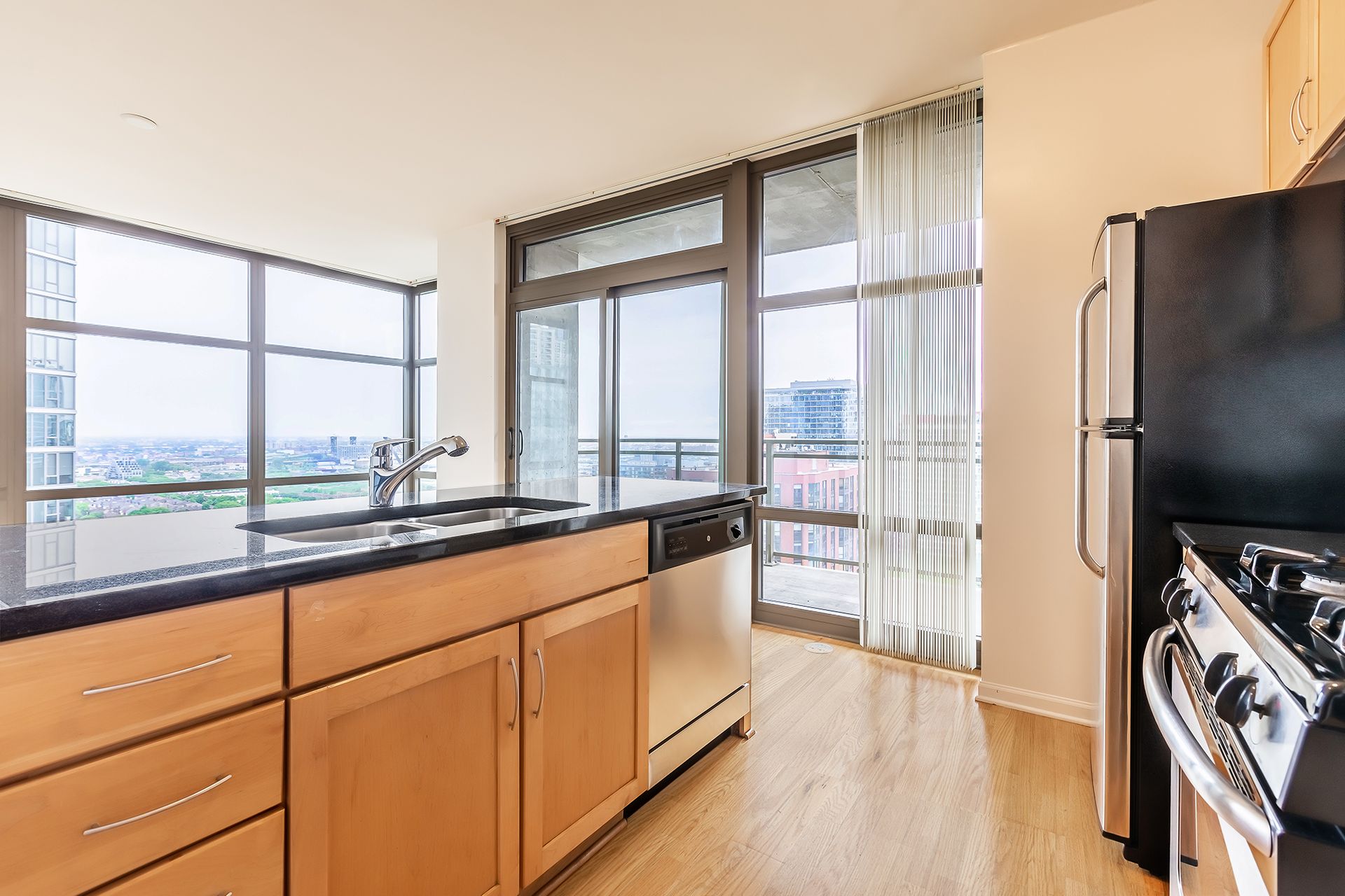 A kitchen with wooden cabinets and a black refrigerator