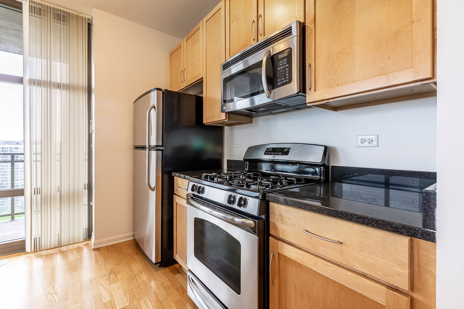 A kitchen with stainless steel appliances and wooden cabinets