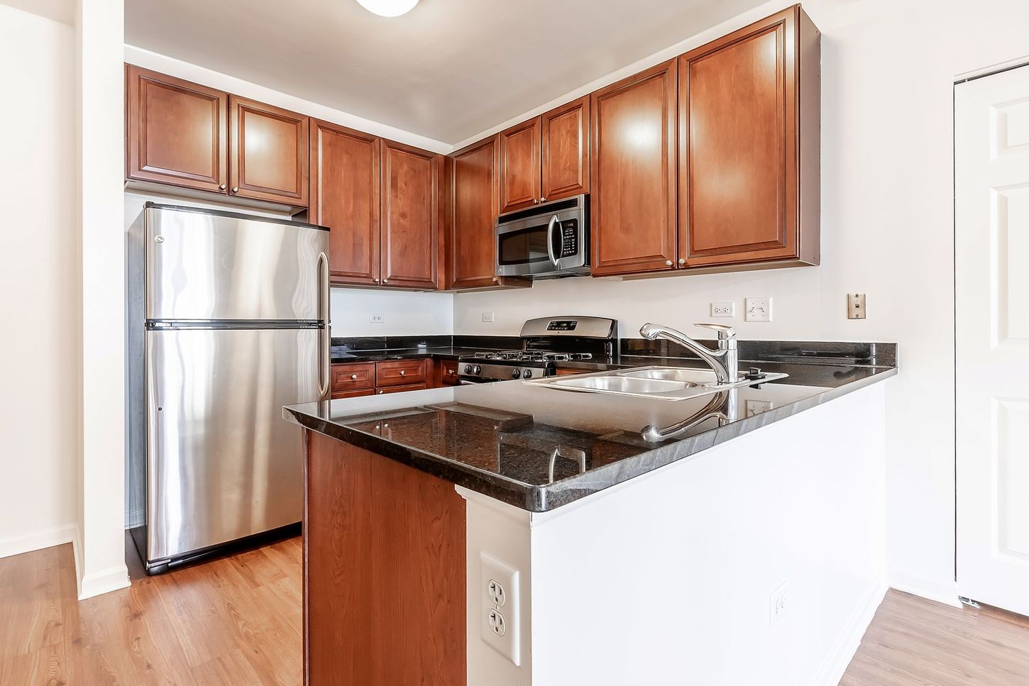 A kitchen with stainless steel appliances and wooden cabinets