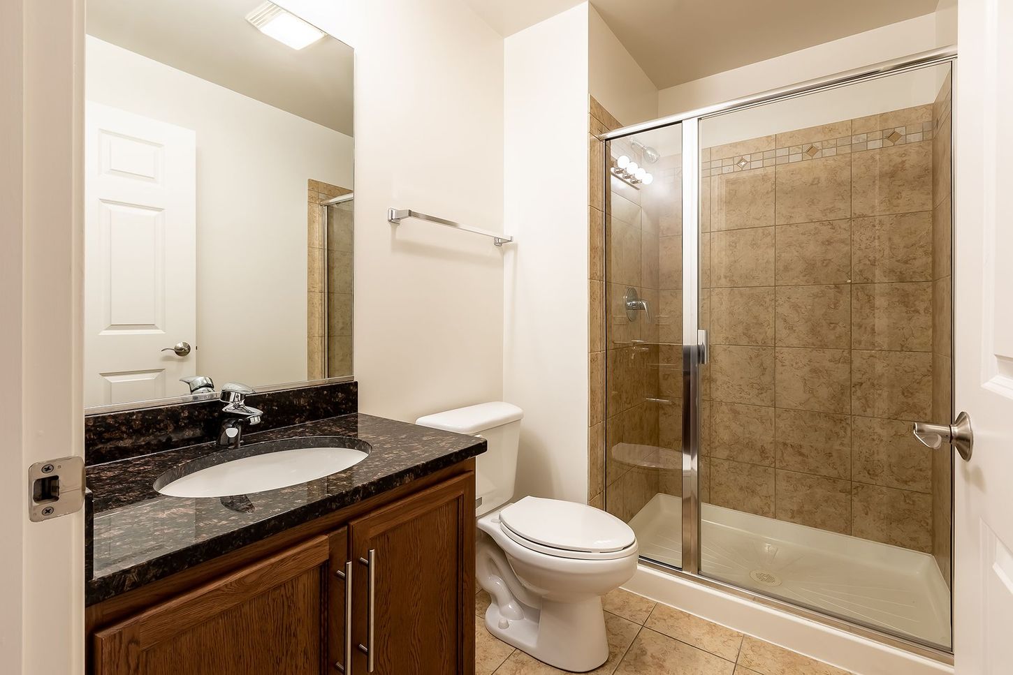 A bathroom with a toilet , sink , and shower.