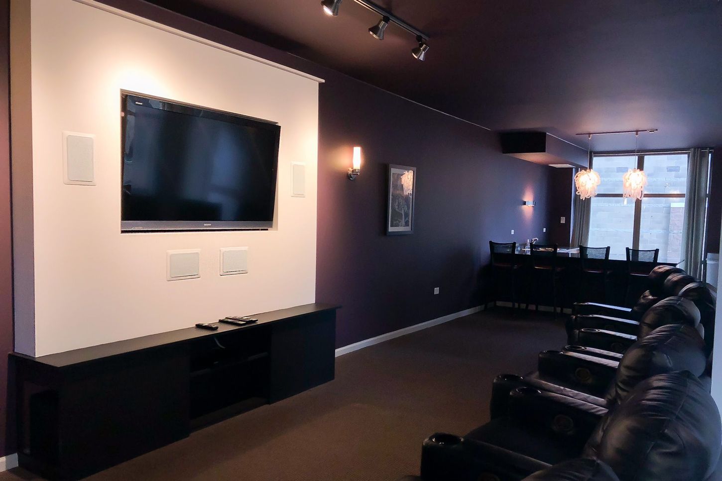 A home theater with purple walls and a flat screen tv