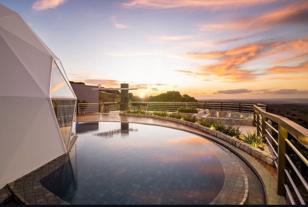 Uma grande piscina com um pôr do sol ao fundo