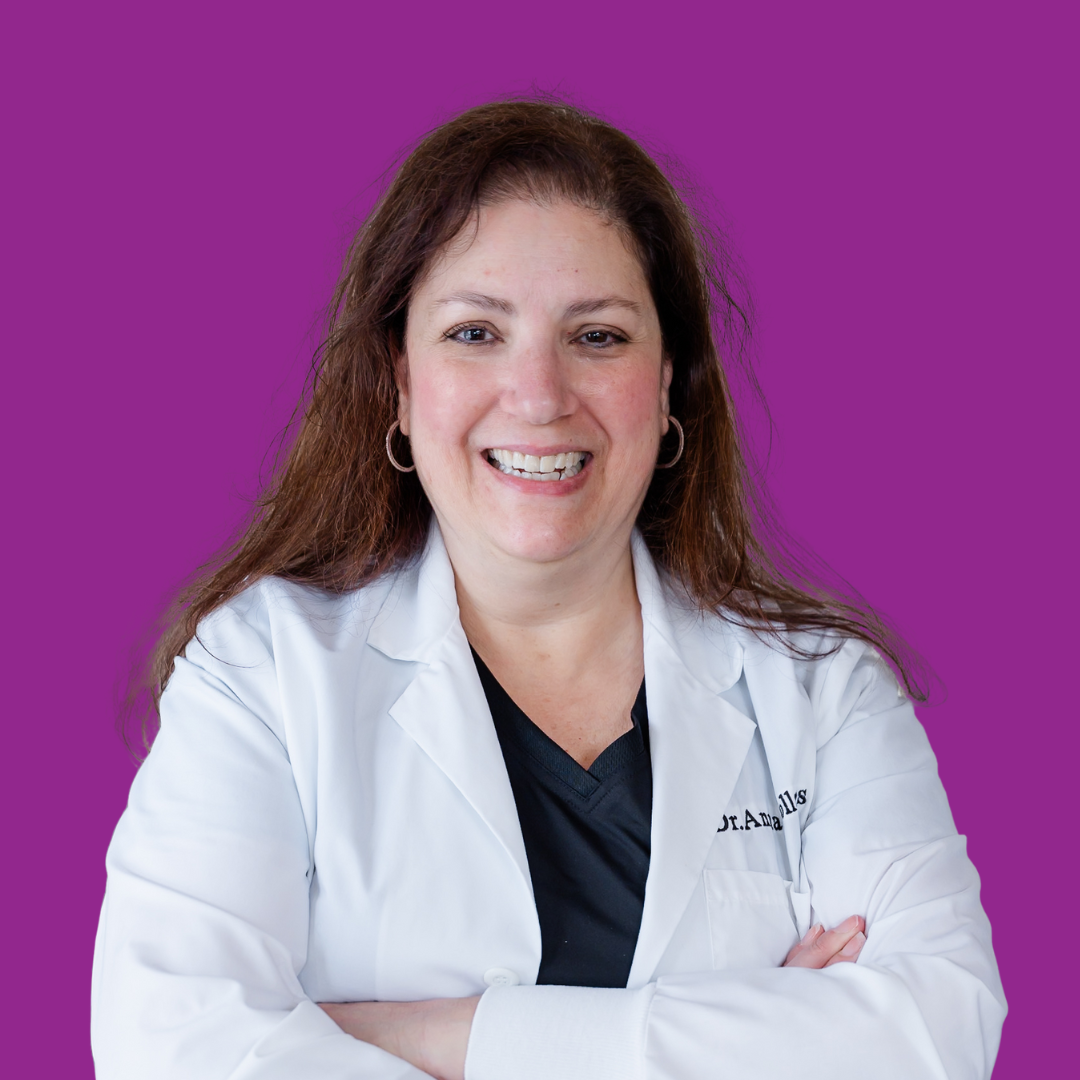 Woman in a white coat smiling, arms crossed, purple background.