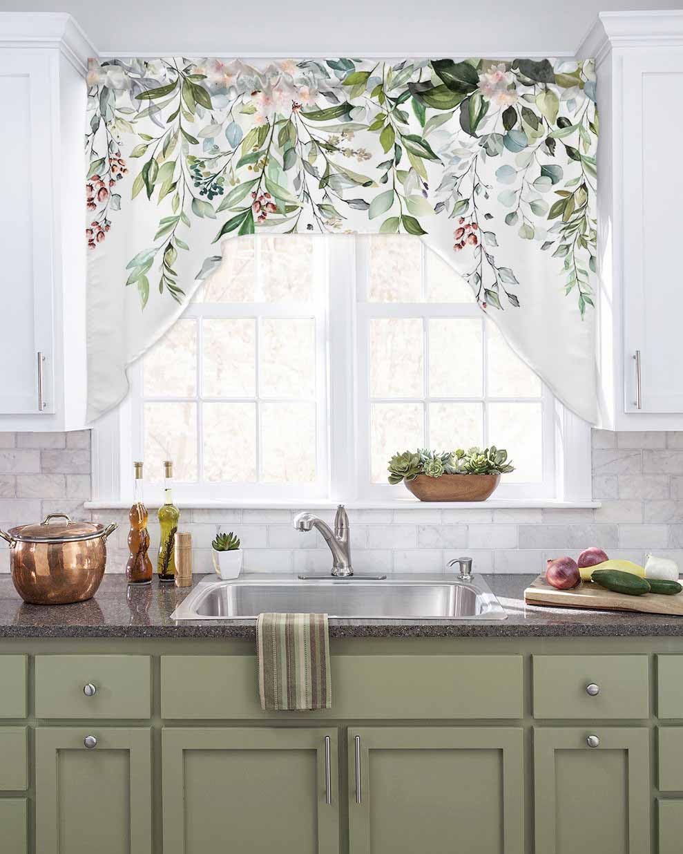 Kitchen with green cabinets, a sink, and floral window valance.