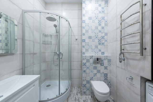 A bathroom with a toilet , sink , and shower stall.