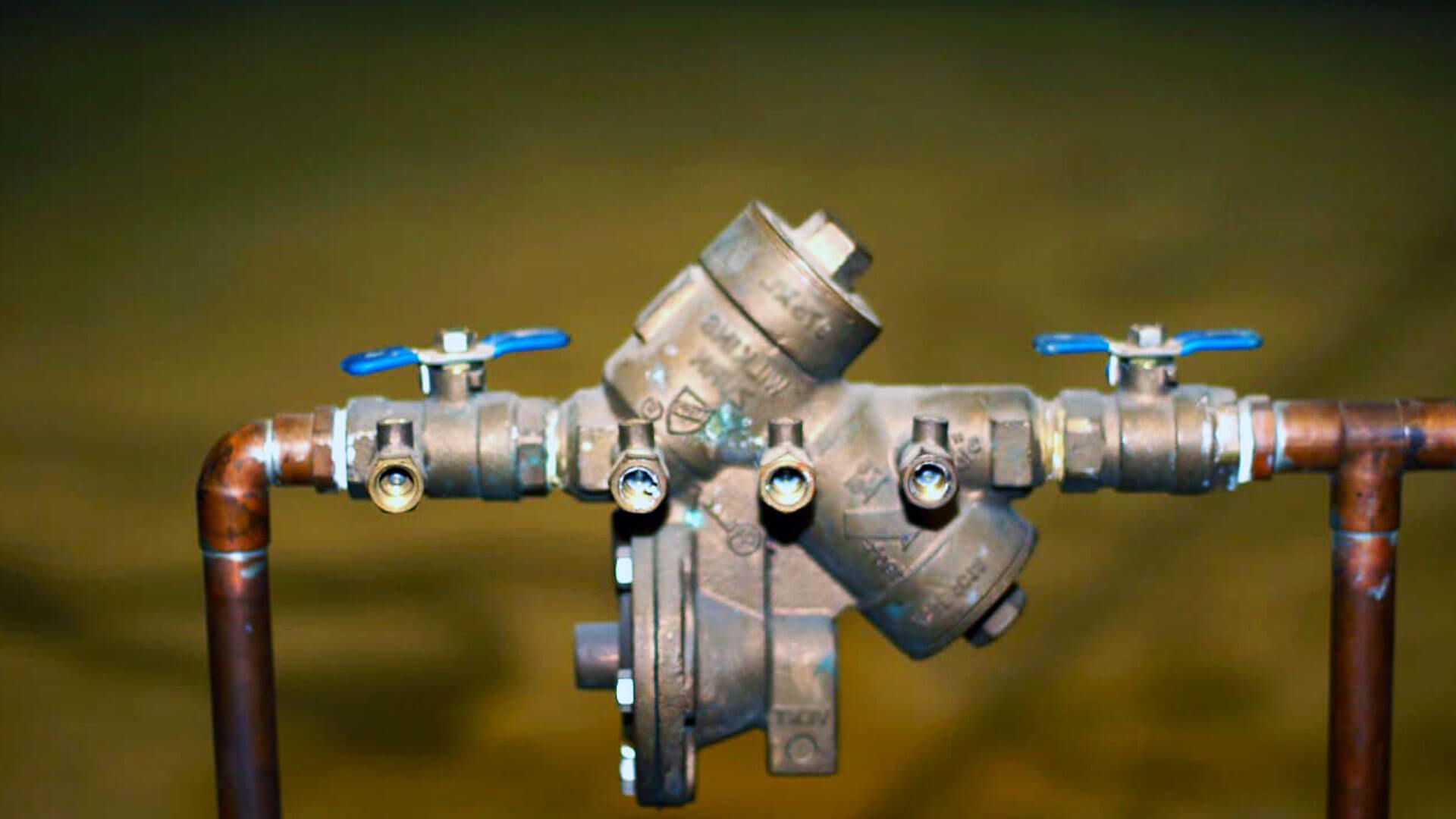 A close up of a water valve on a copper pipe.