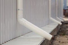 New white rain gutter on building with white metal sheet - The Sprinkler Company, LLC