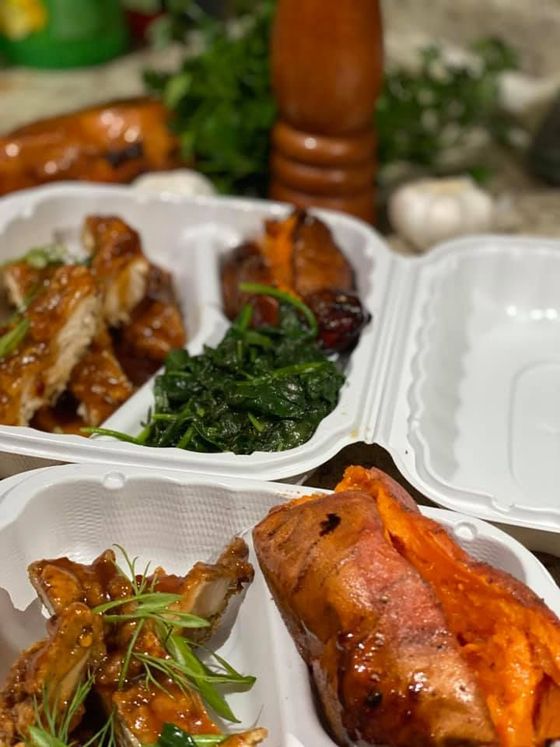 Buffet table with sliced meats, bread, crackers, and pastries arranged in trays at a restaurant