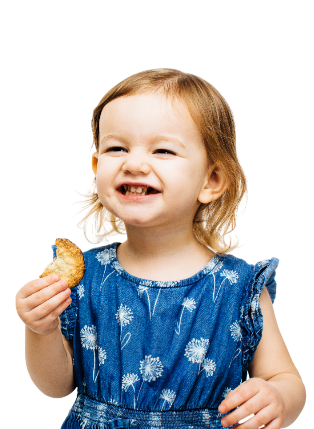 Boy with curly brown hair smiles with arms crossed, wearing a white button-down shirt.