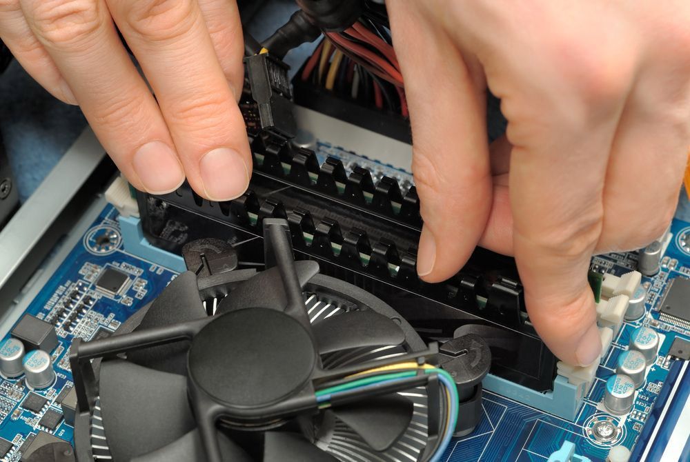 Technician's Hands Installing User Memory On A Computer Main Board — Essential Computer Repairs In Caloundra QLD