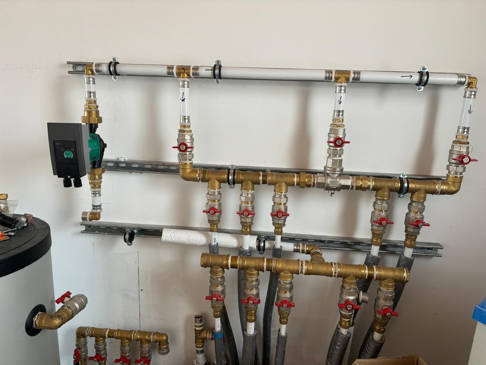 Un mucchio di tubi di ottone sono appesi a un muro