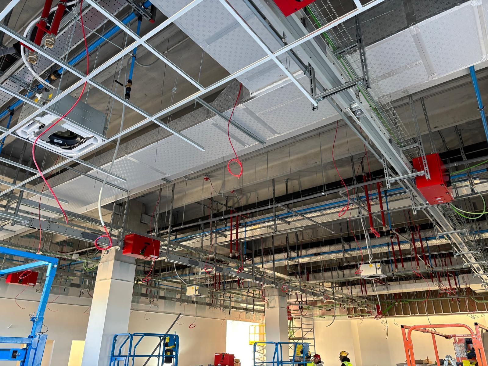 Una grande stanza con un sacco di tubi che pendono dal soffitto.