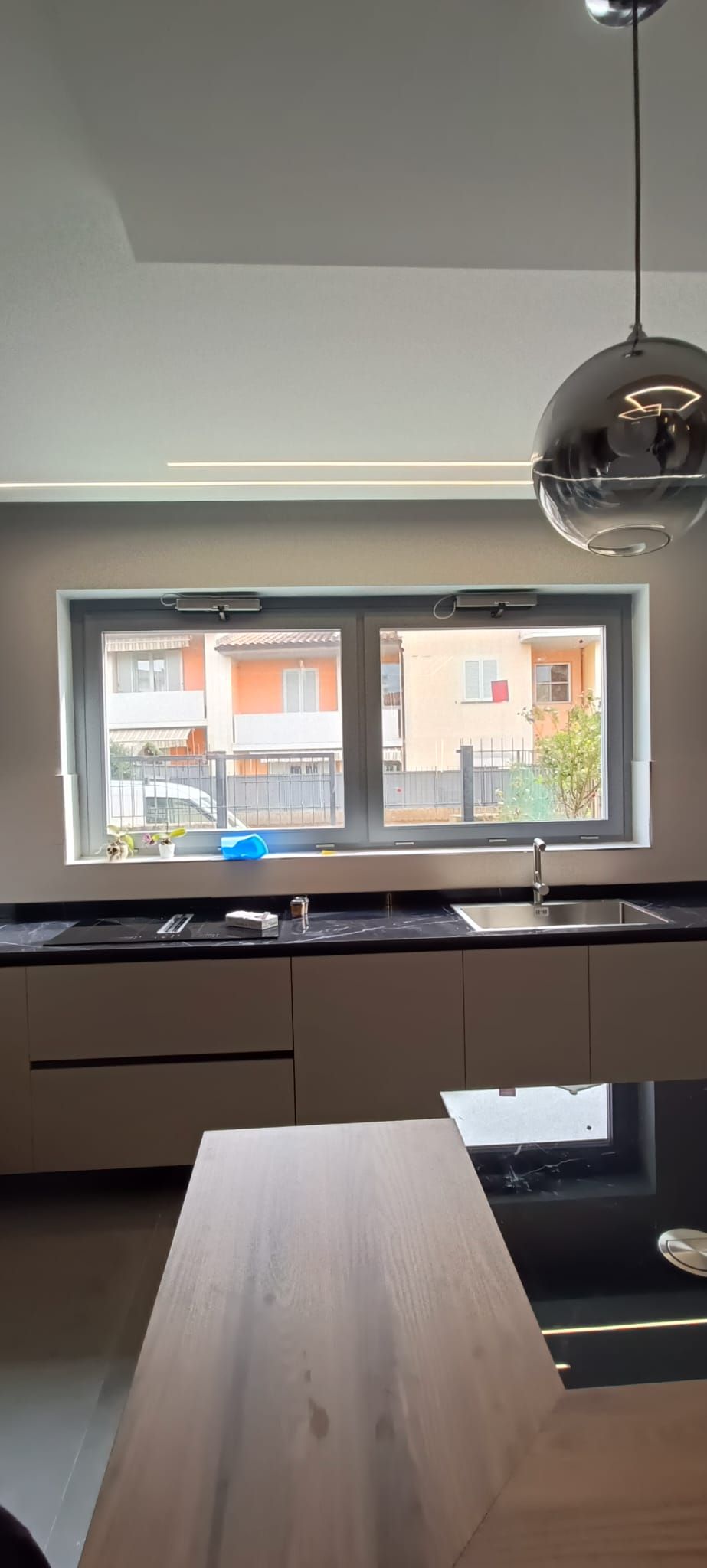 Cucina moderna con finestra e lampada a sospensione.