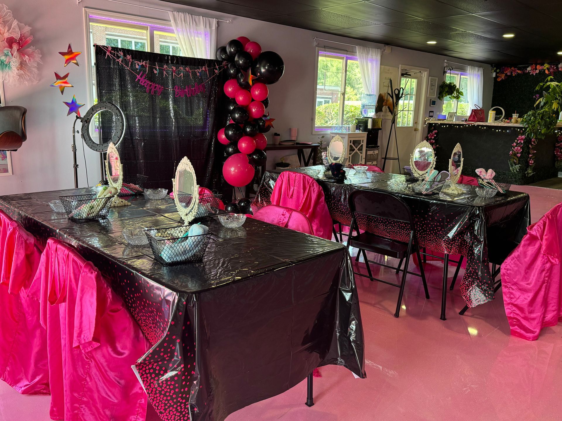 A room filled with tables and chairs decorated for a party.