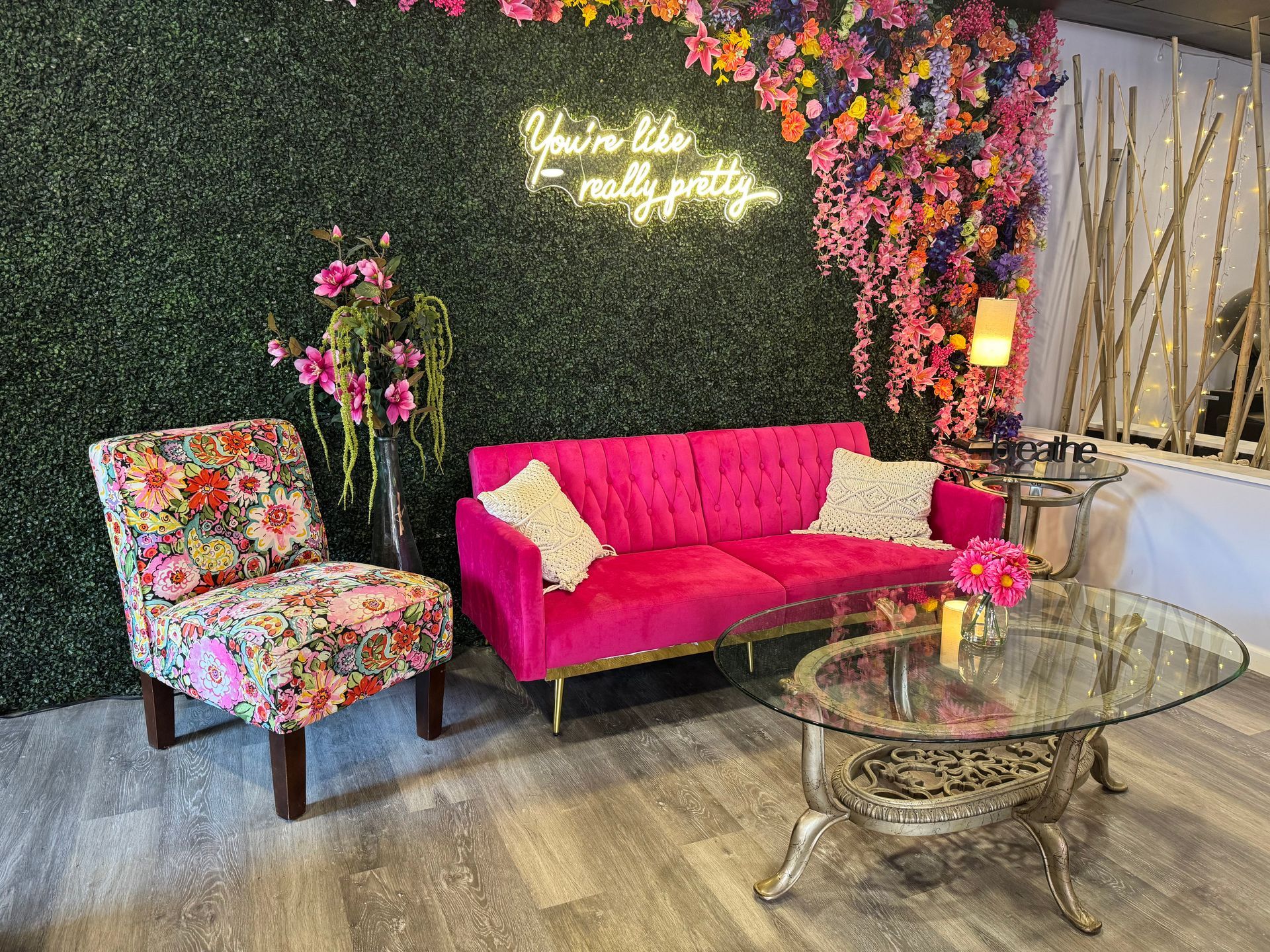 A living room with a pink couch , chairs , and a coffee table.