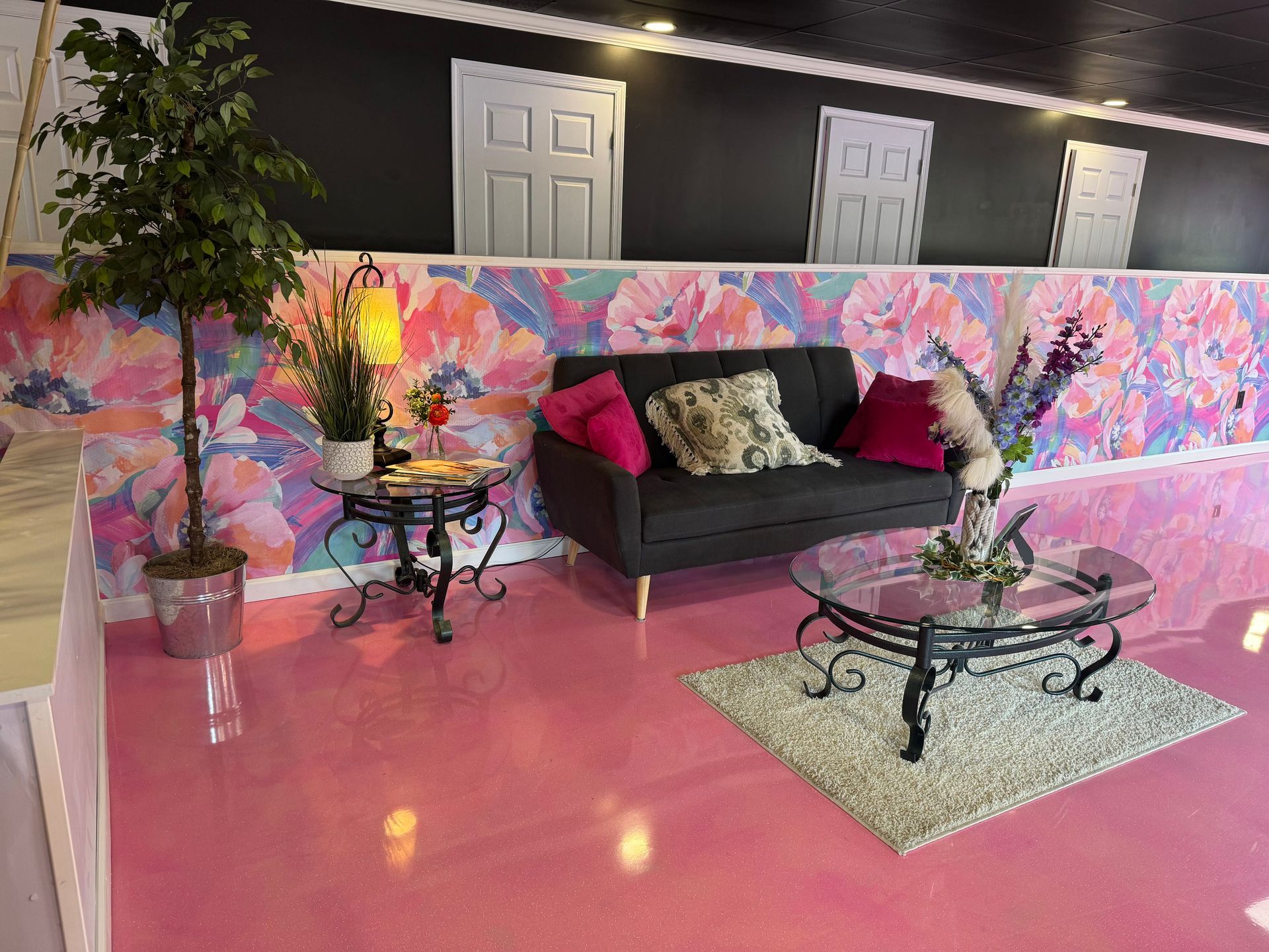 A living room with a couch , coffee table , and a pink floor.