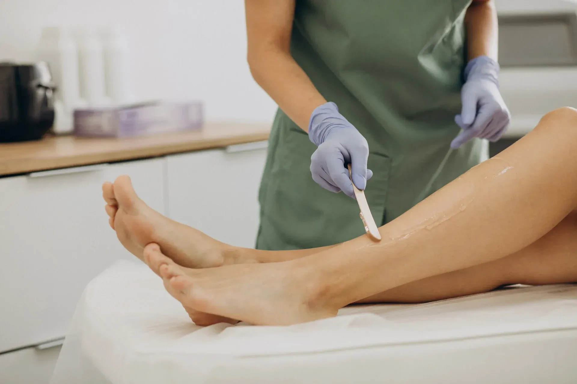 A woman is getting her legs waxed in a beauty salon.